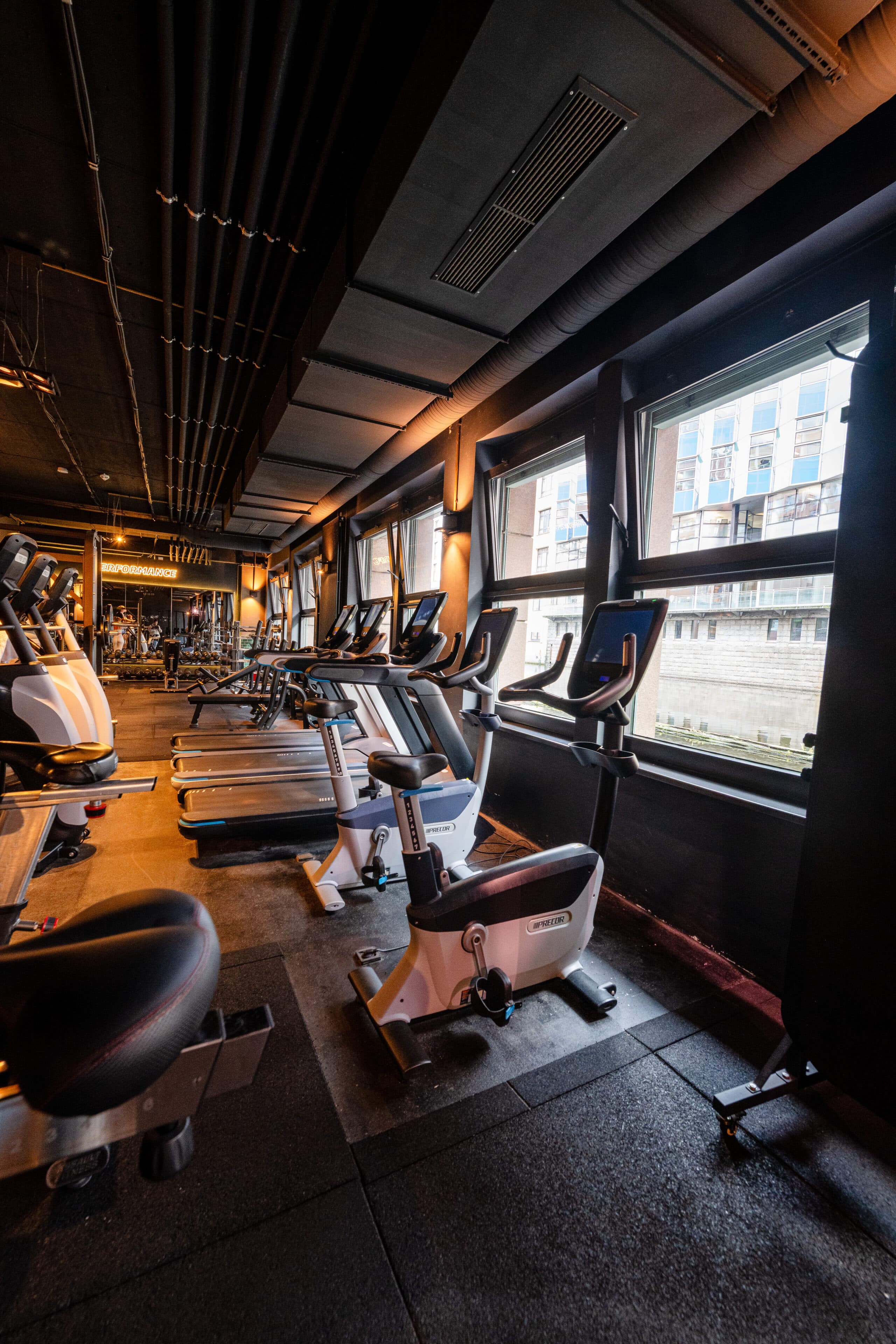 Innenraum eines Fitnessstudios mit mehreren verschiedenen Sportgeräten.